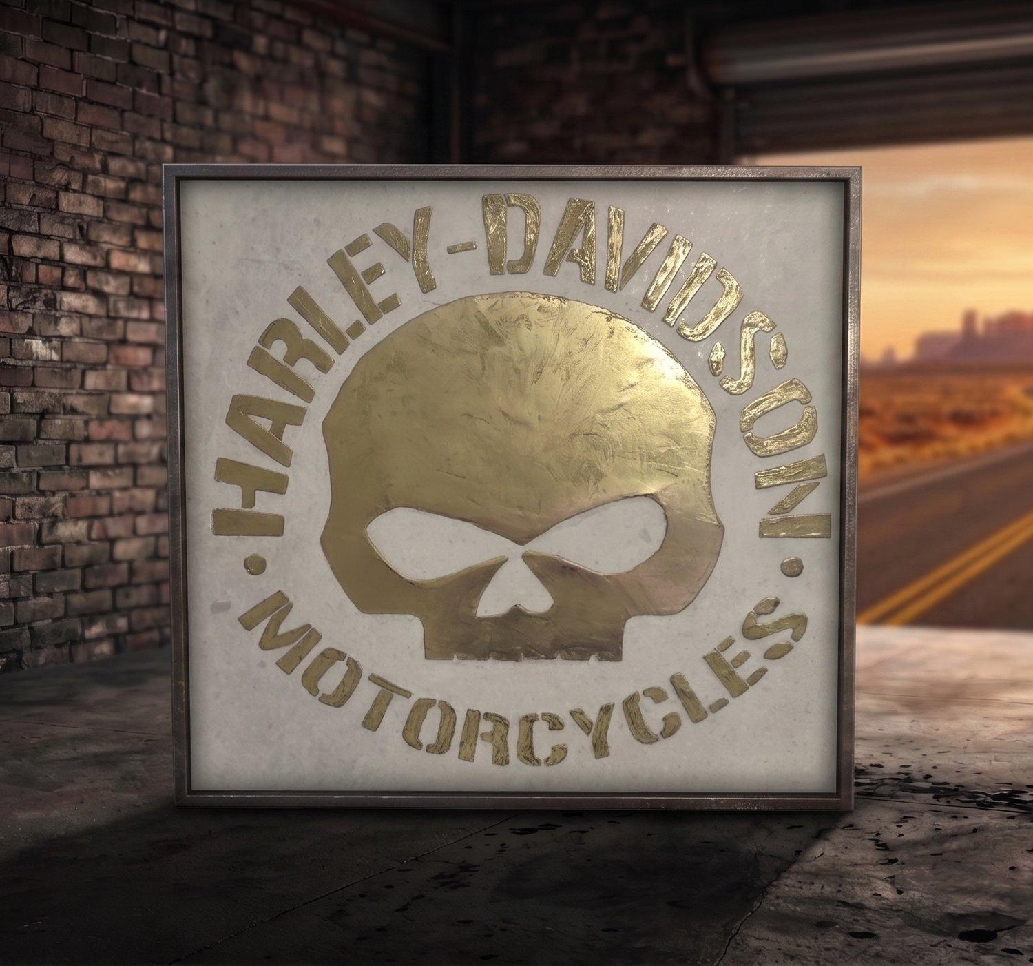 Reaper's Mark I — brass-tone Harley-Davidson skull relief on ceramic tile, staged in the workshop with a Route 66 desert highway beyond